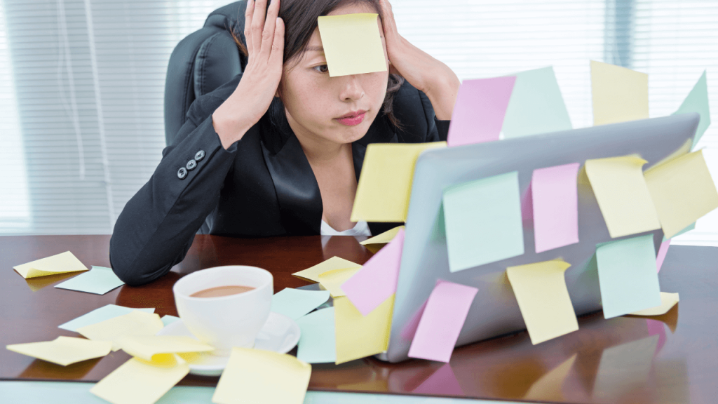 A person stressed at work with multiple post it notes everywhere